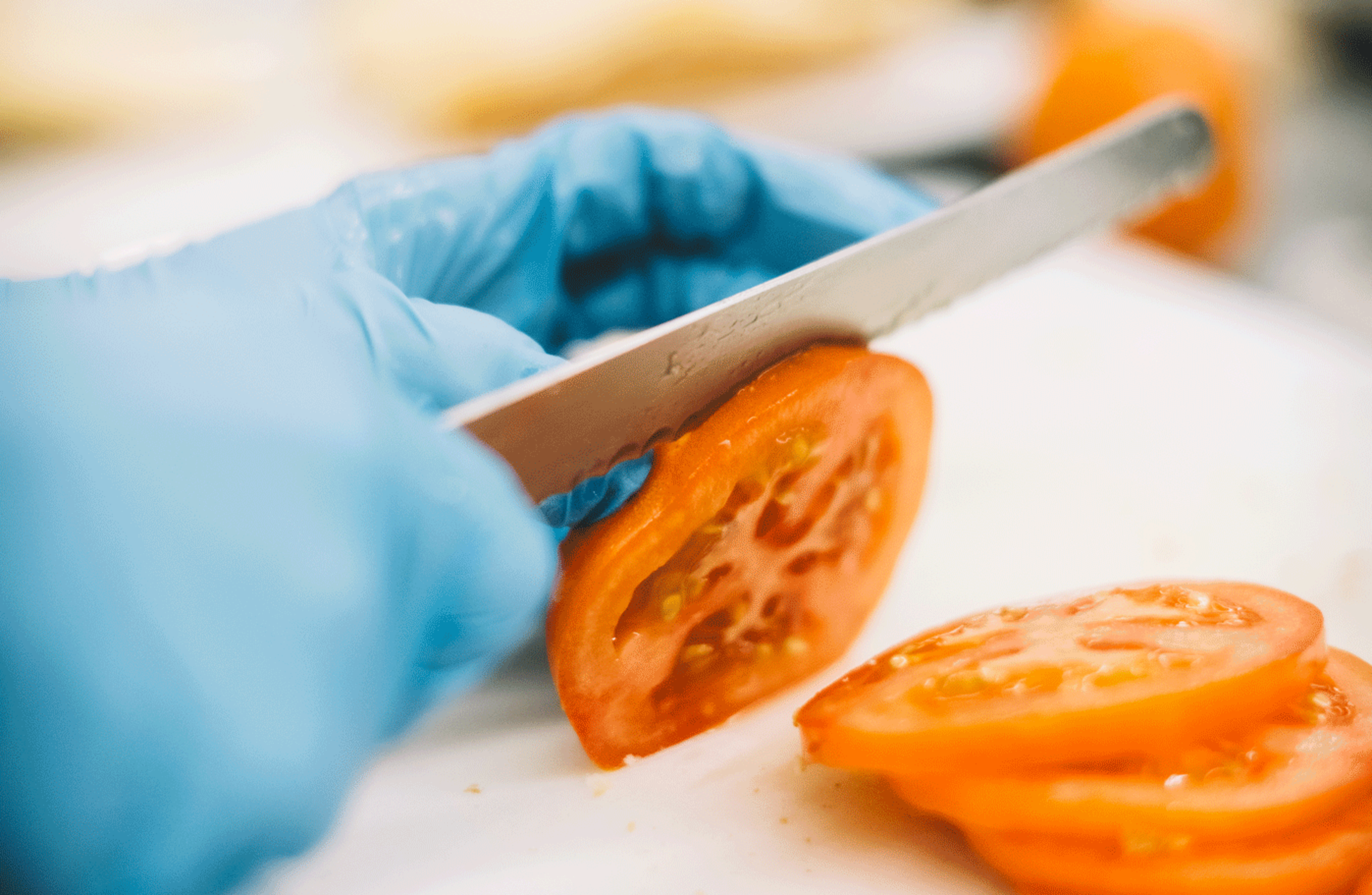Gemüse schneiden Nahaufnahme vom Schneiden einer Tomate mit einem Messer.