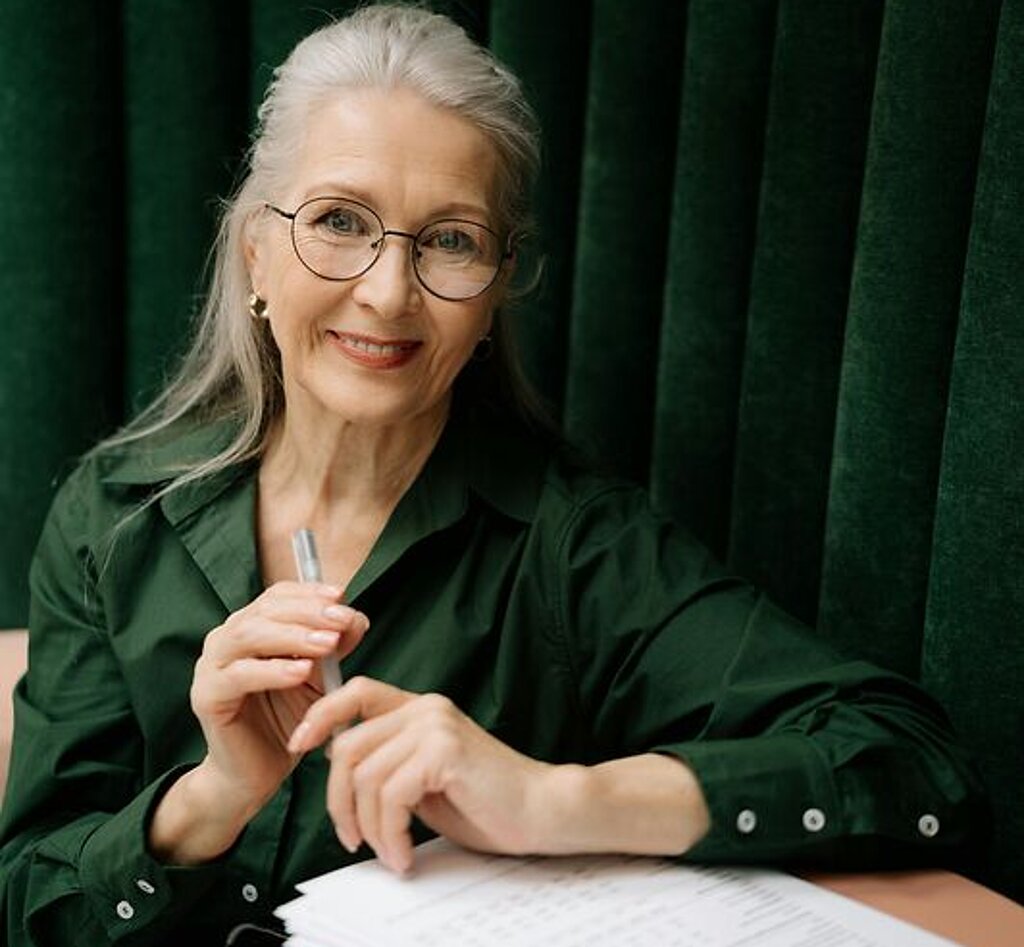 Frau mit Formular Eine Frau mittleren Alters füllt ein Formular aus.