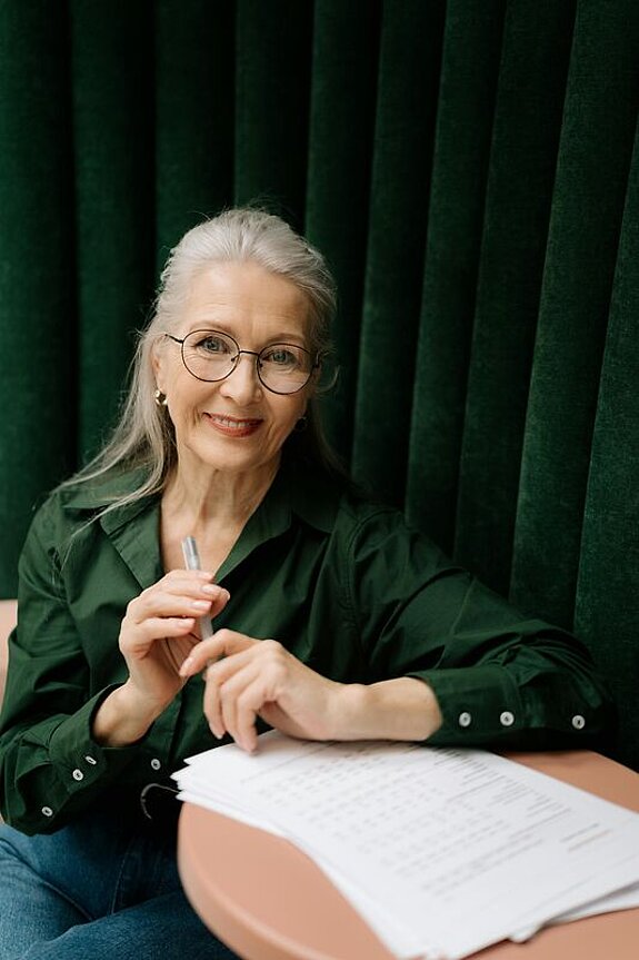 Eine Frau mittleren Alters füllt ein Formular aus.