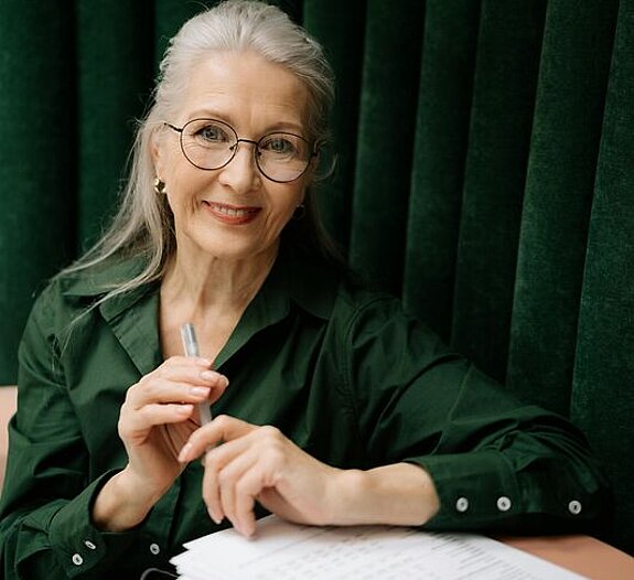 Frau mit Formular Eine Frau mittleren Alters füllt ein Formular aus.