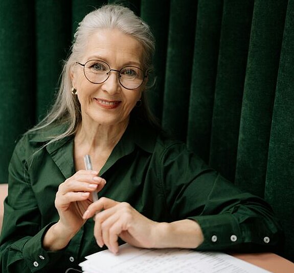 Eine Frau mittleren Alters füllt ein Formular aus.