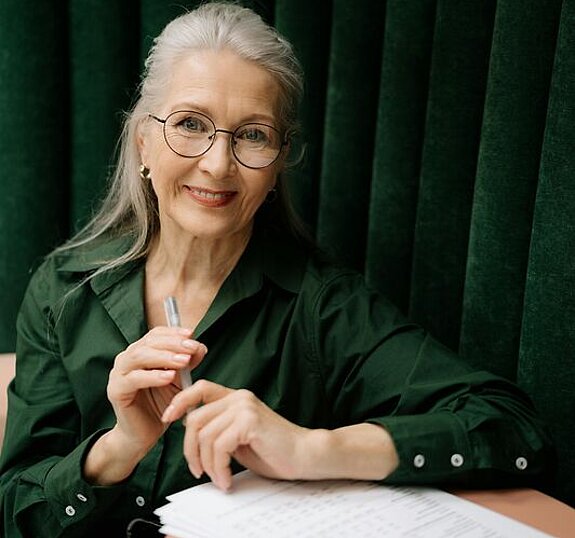 Frau mit Formular Eine Frau mittleren Alters füllt ein Formular aus.