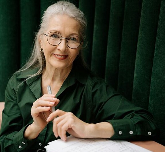 Eine Frau mittleren Alters füllt ein Formular aus.