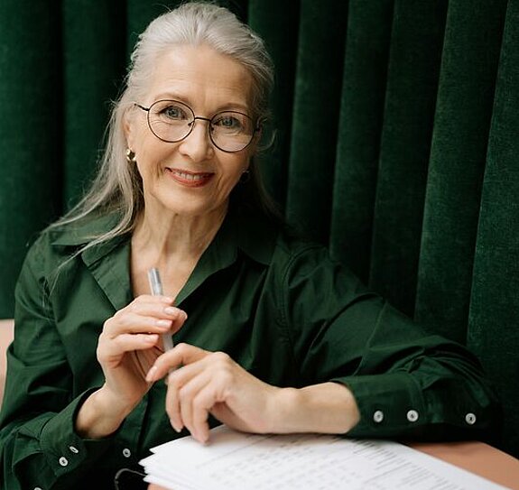 Eine Frau mittleren Alters füllt ein Formular aus.