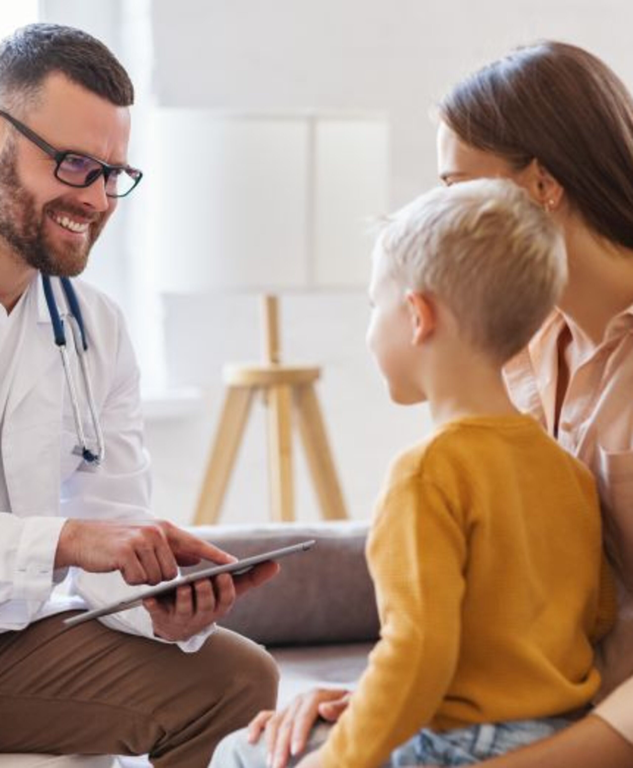 Arztgespräch Pädiatrie Ein Arzt redet mit einer Mutter mit Sohn.