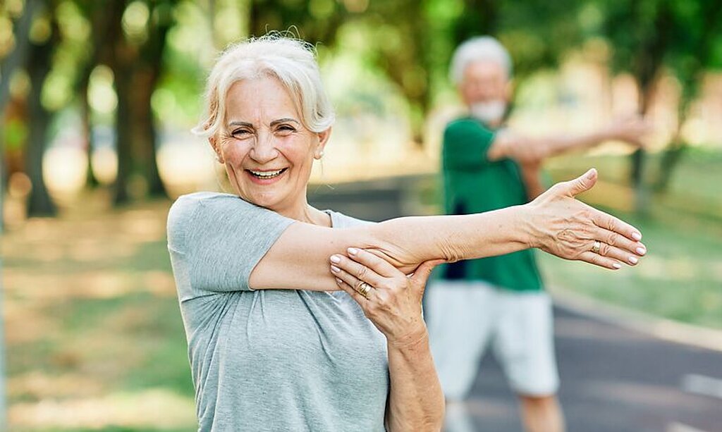 Frau Dehnt sich im Park.