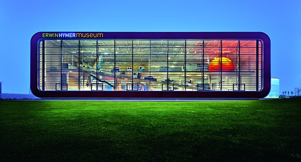 ehm_gebäude_bei_nacht odernes, leuchtendes Gebäude des Erwin Hymer Museums bei Nachtaufnahme.