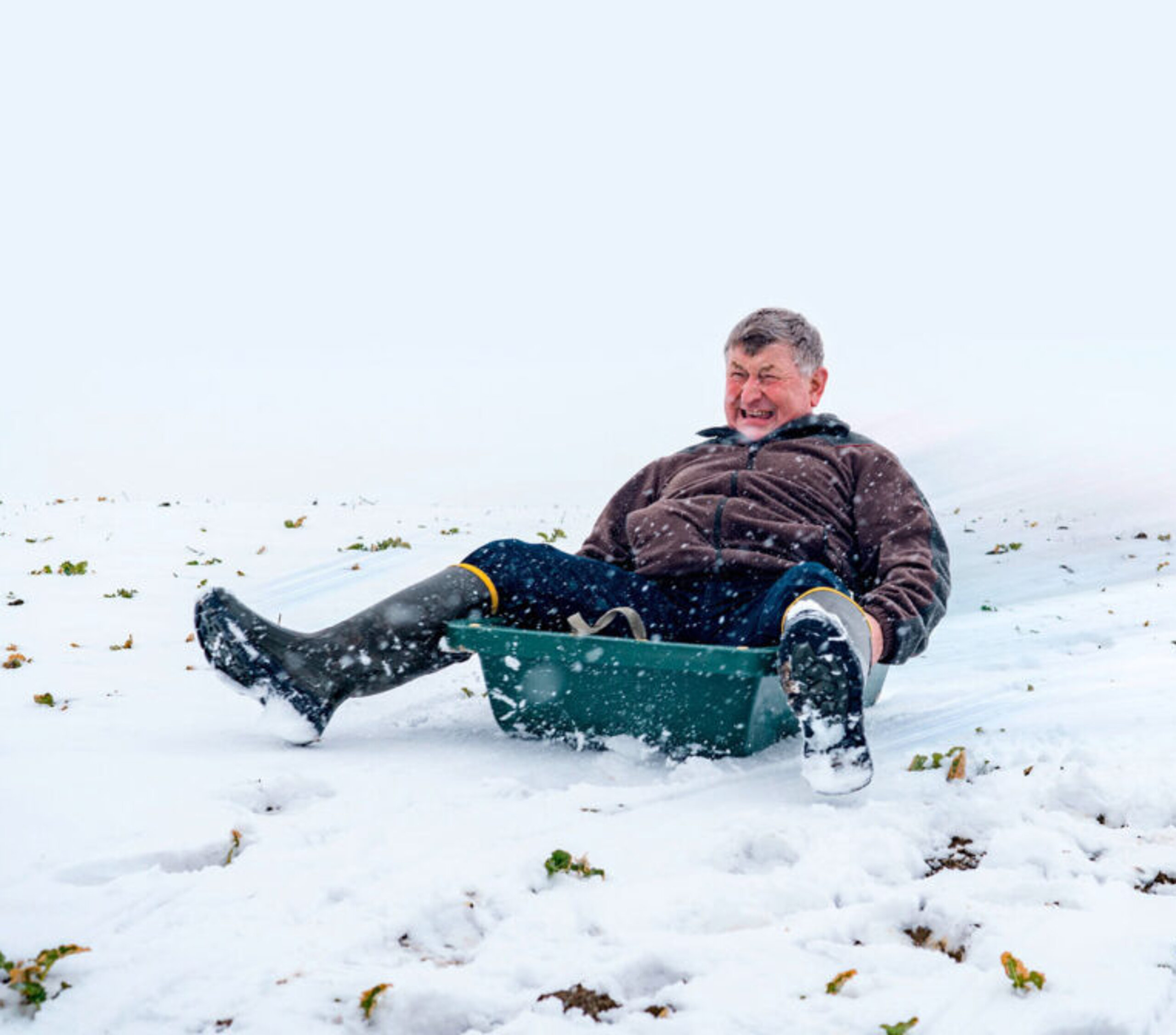 Alter Mann beim Schlittenfahren.