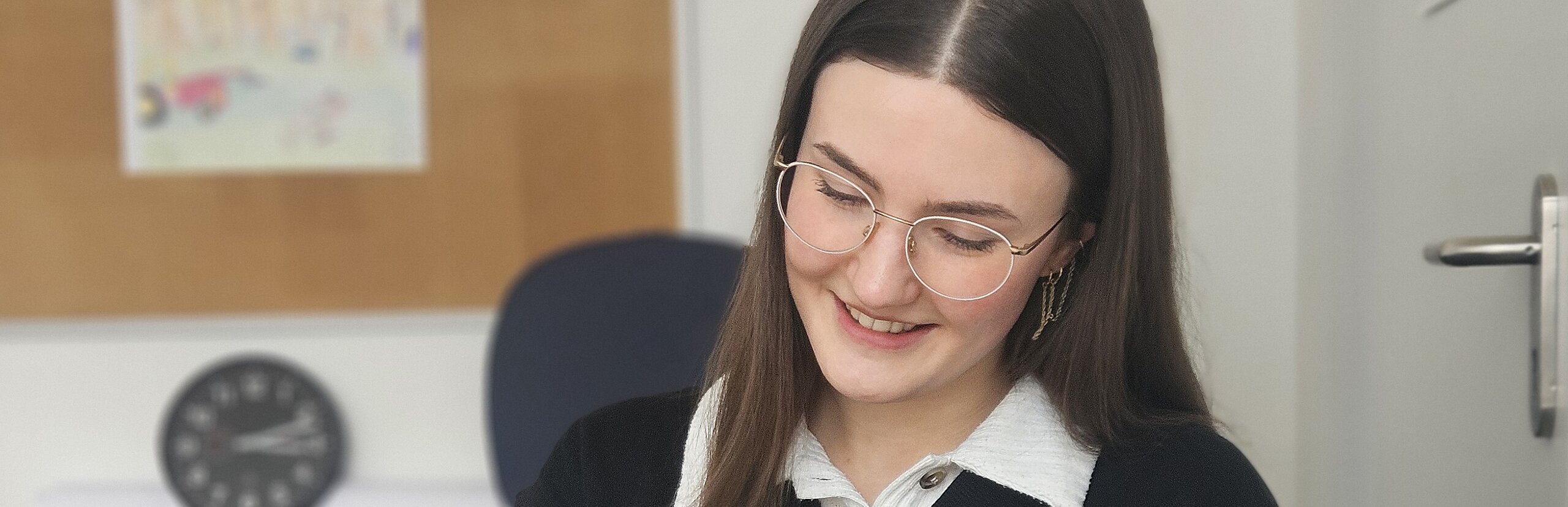 Eine junge Psychologin der KIH sitzt am Schreibtisch und schreibt etwas auf ein Blatt Papier.