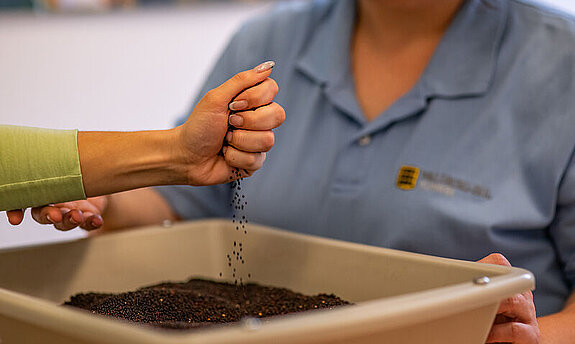 Eine Frau macht Handübungen im Linsenbad.
