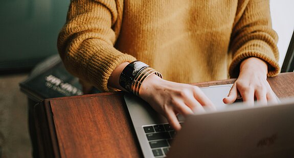 Arbeiten am Laptop Person tippt etwas auf dem Laptop.