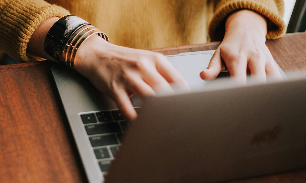 Person tippt etwas auf dem Laptop.