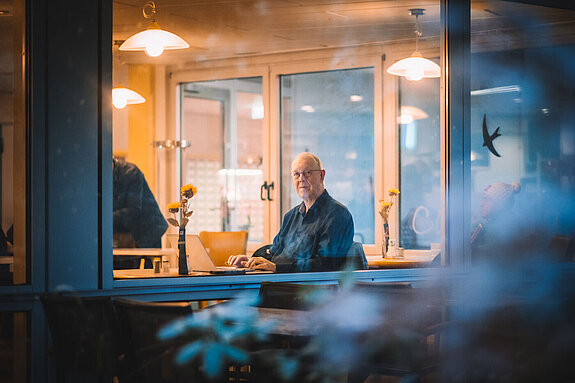 Ingo Nauhaus schreibt in der Cafeteria an seinem Buch.