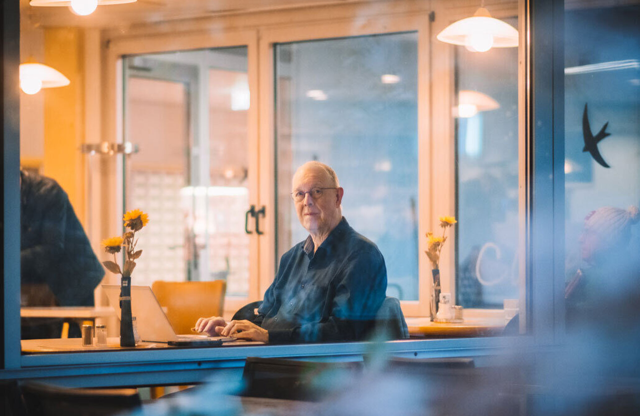 Ein Rehagast schreibt am Essenstisch im Speisesaal.