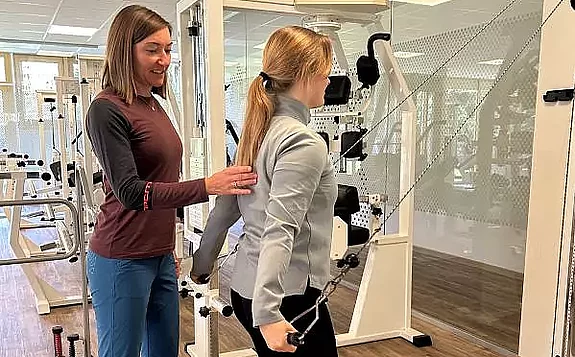 Betreuung MTT Training Eine Therapeutin betreut eine Patientin im MTT am Seilzug.