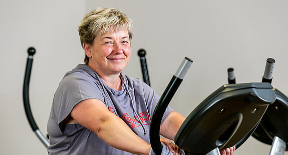Ergometertraining Eine Frau trainiert auf dem Fahrradergometer indoor.