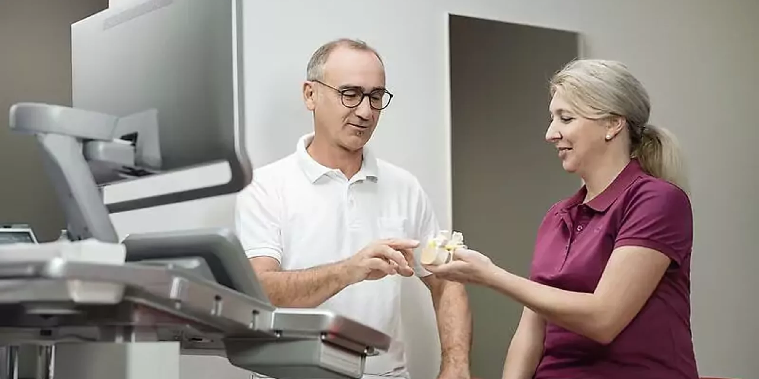 Ein Arzt zeigt einer Patientin etwas an einem Knochenmodel.
