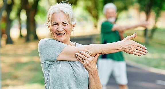 Gymnastik im Park Eine Patientin macht Gymnastikübungen im Park.