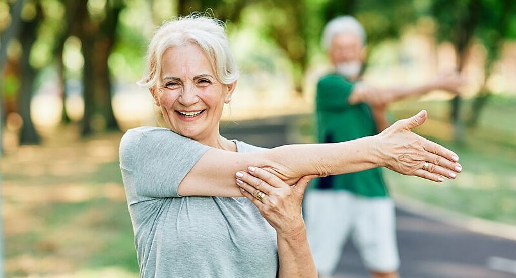 Gymnastik im Park Eine Patientin macht Gymnastikübungen im Park.