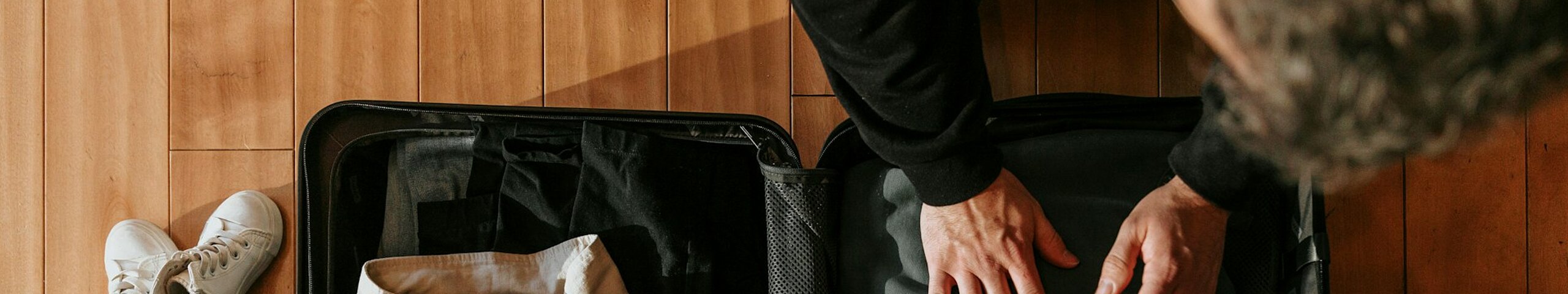 Eine Person packt einen Koffer.