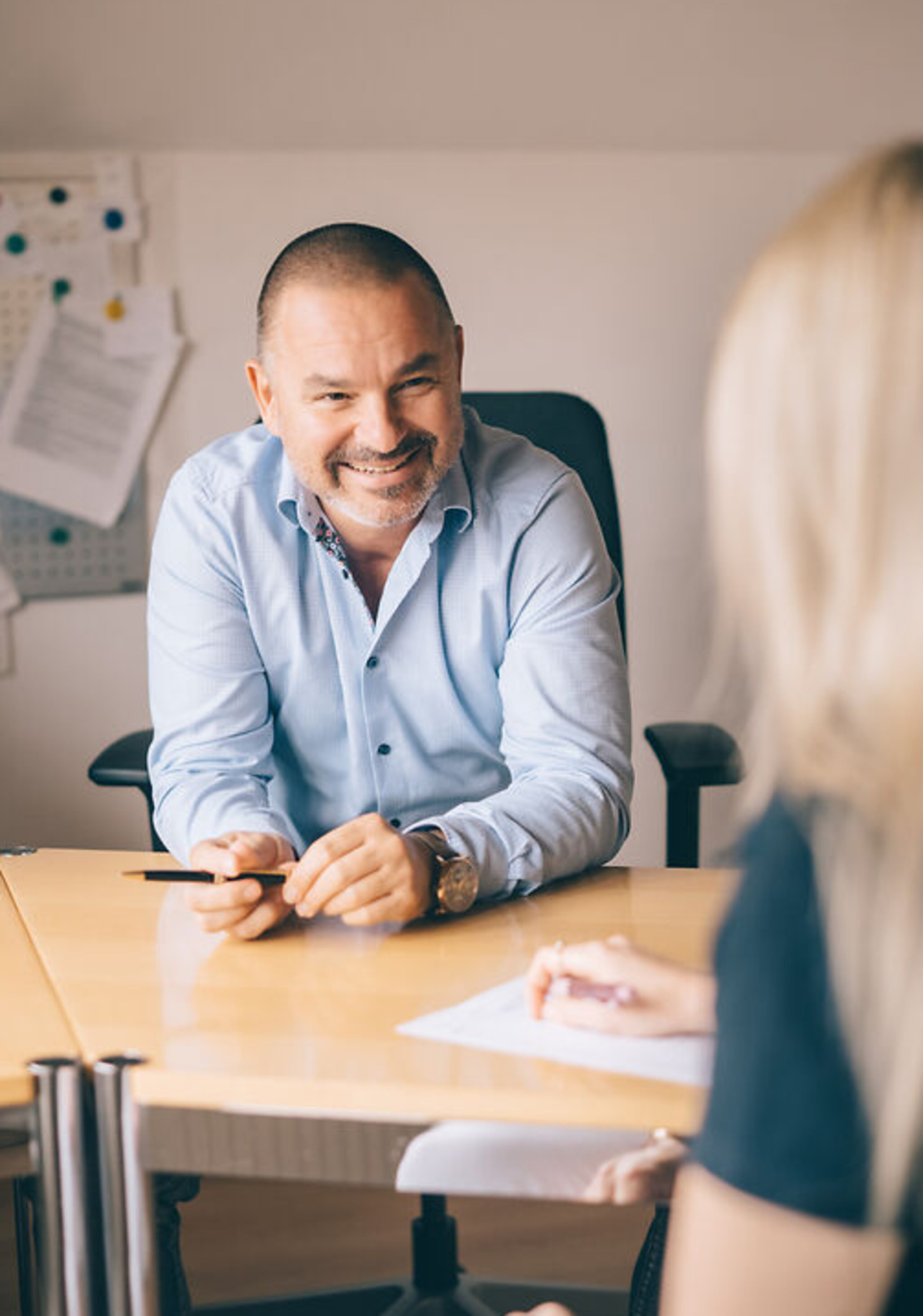 Arzt im blauen Hemd sitz lächeln vor Patientin