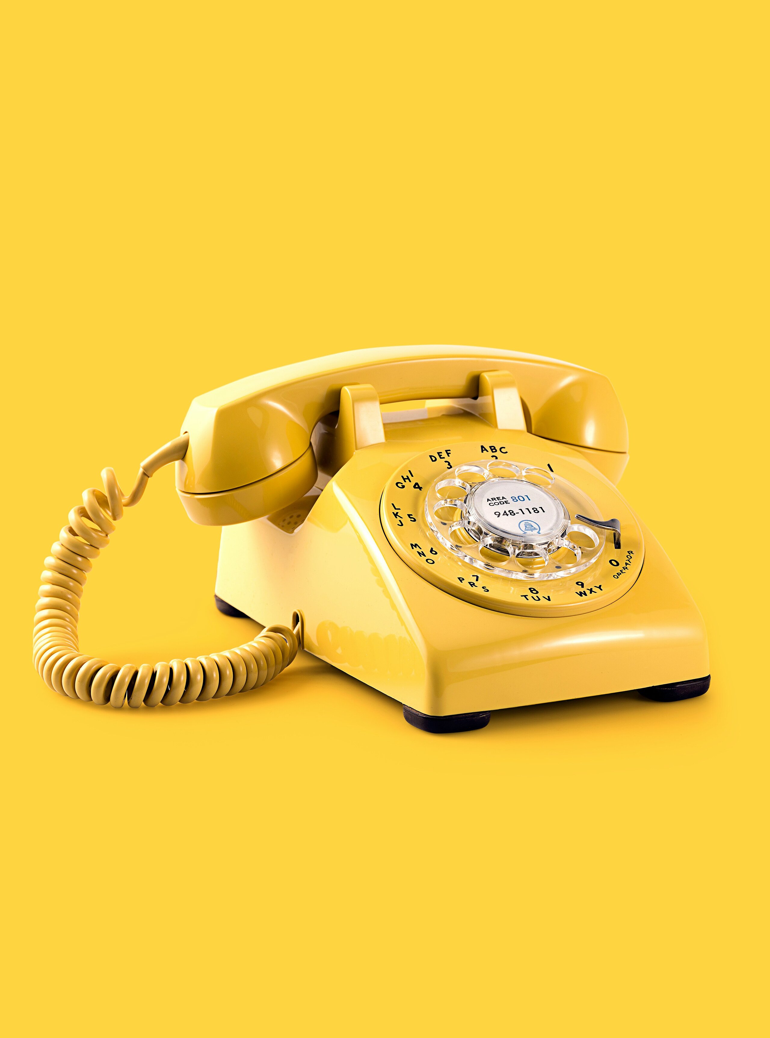 Gelbes Telefon mit Ziffernblatt und gelben Hintergrund