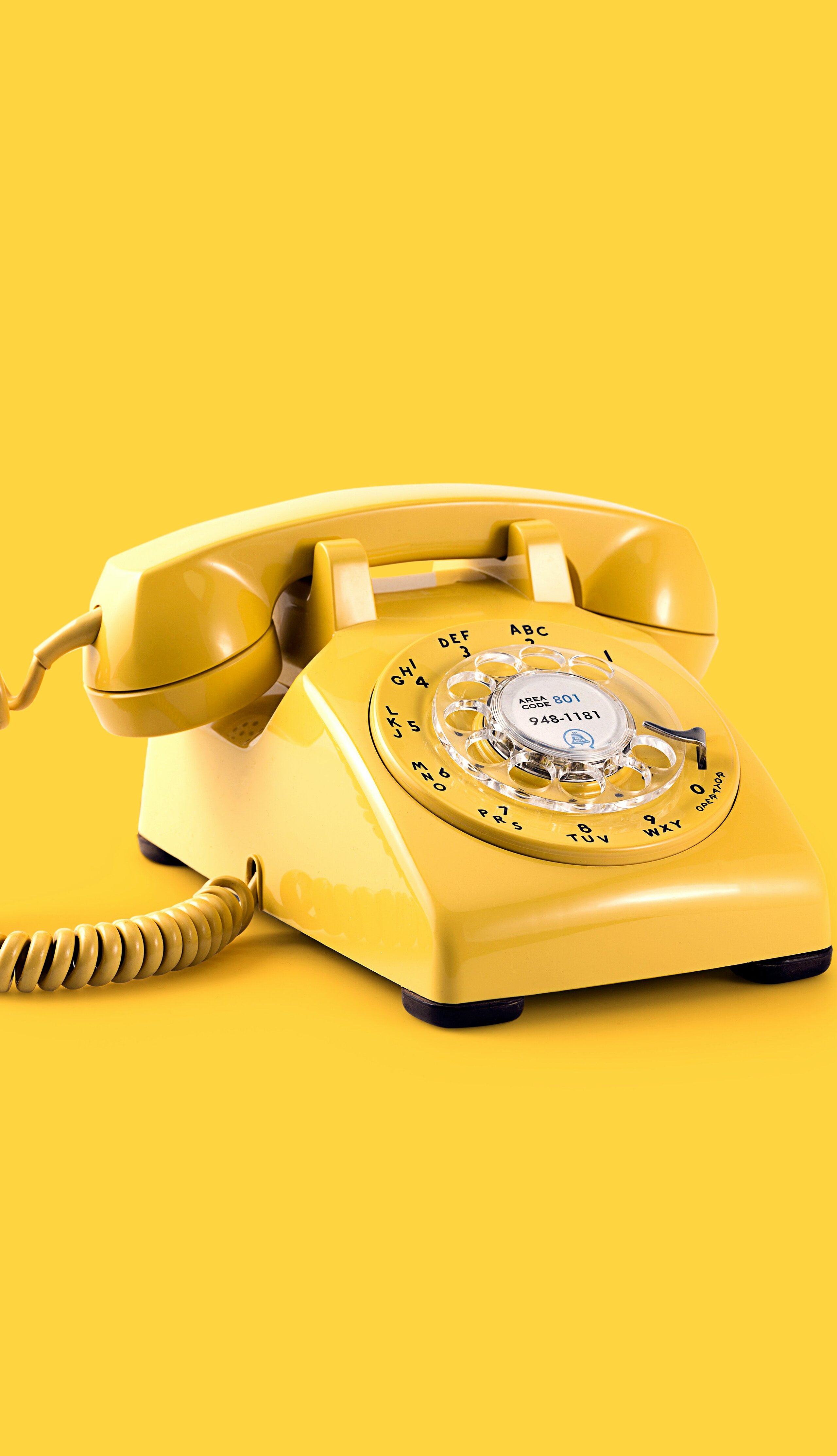Gelbes Telefon mit Ziffernblatt und gelben Hintergrund