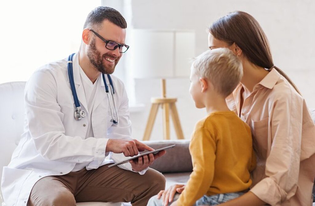 Ein Arzt redet mit einer Mutter mit Sohn.