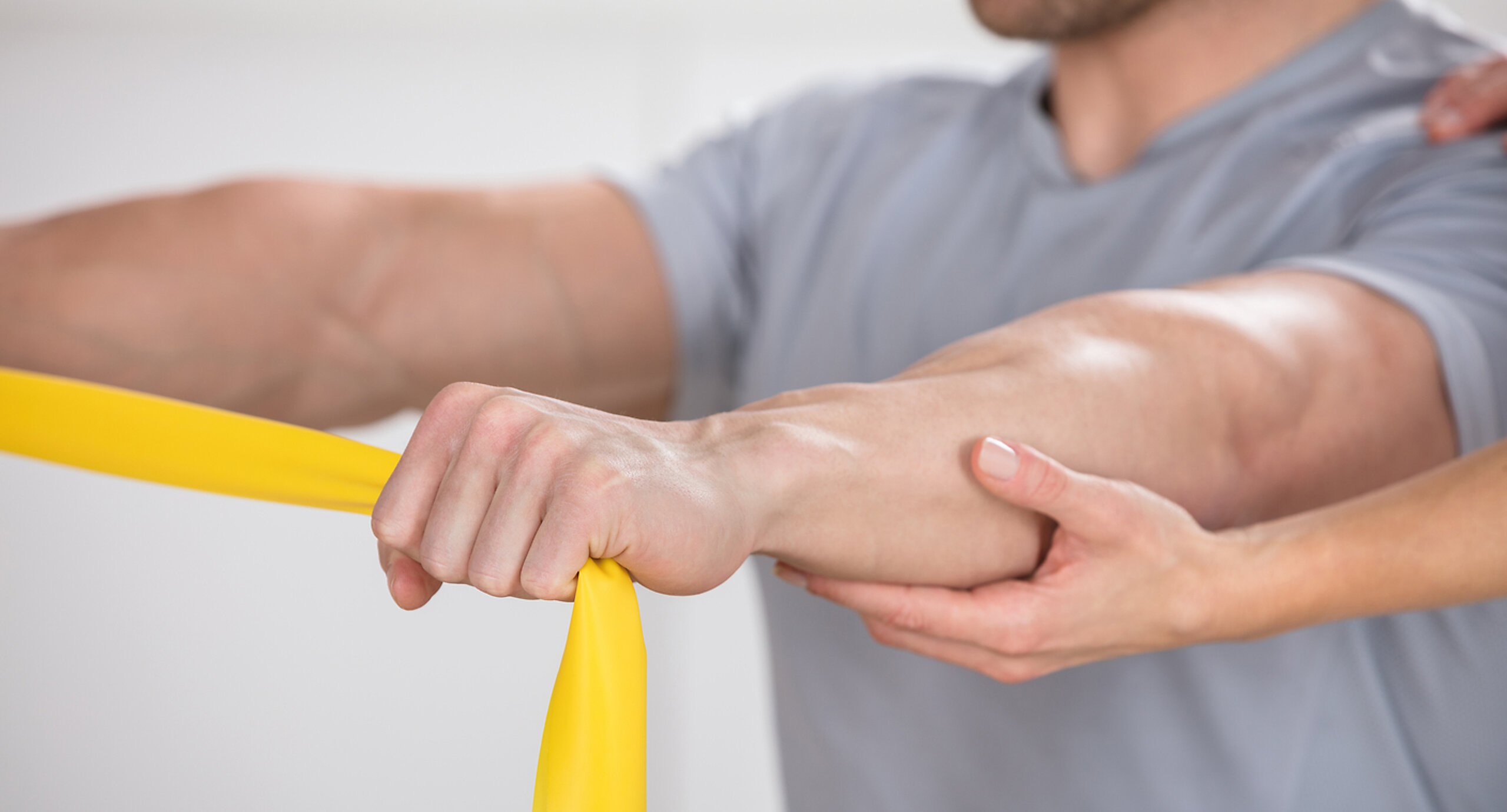 Ein Mann trainiert mit einem Theraband.