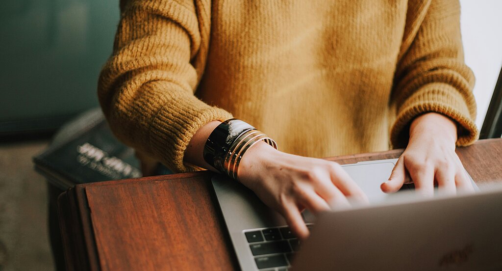 Person tippt etwas auf dem Laptop.