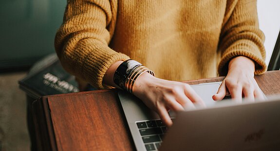 Person tippt etwas auf dem Laptop.
