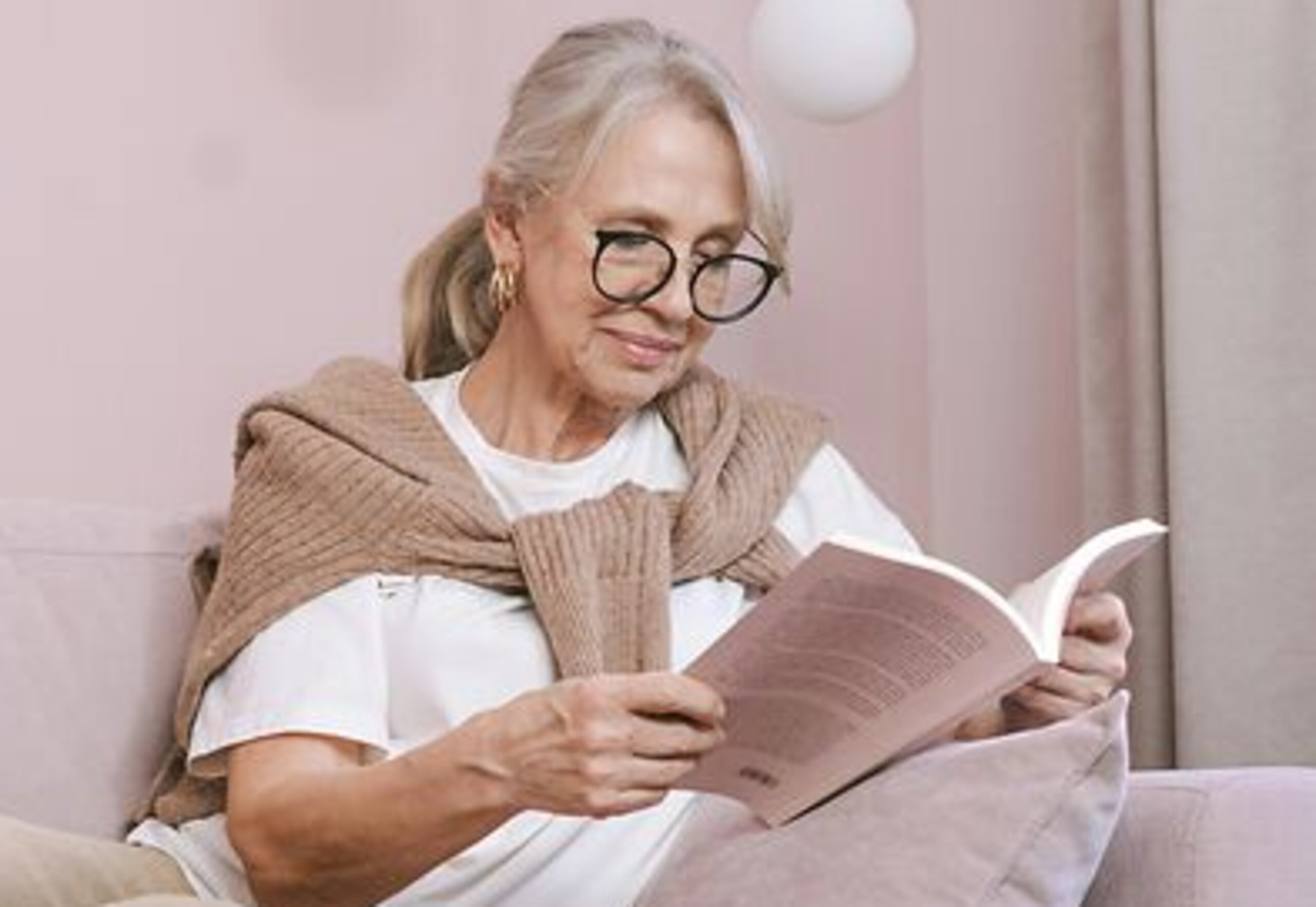 Frau ließt ein Buch Eine Frau ließt zuhause ein Buch auf dem Sofa.