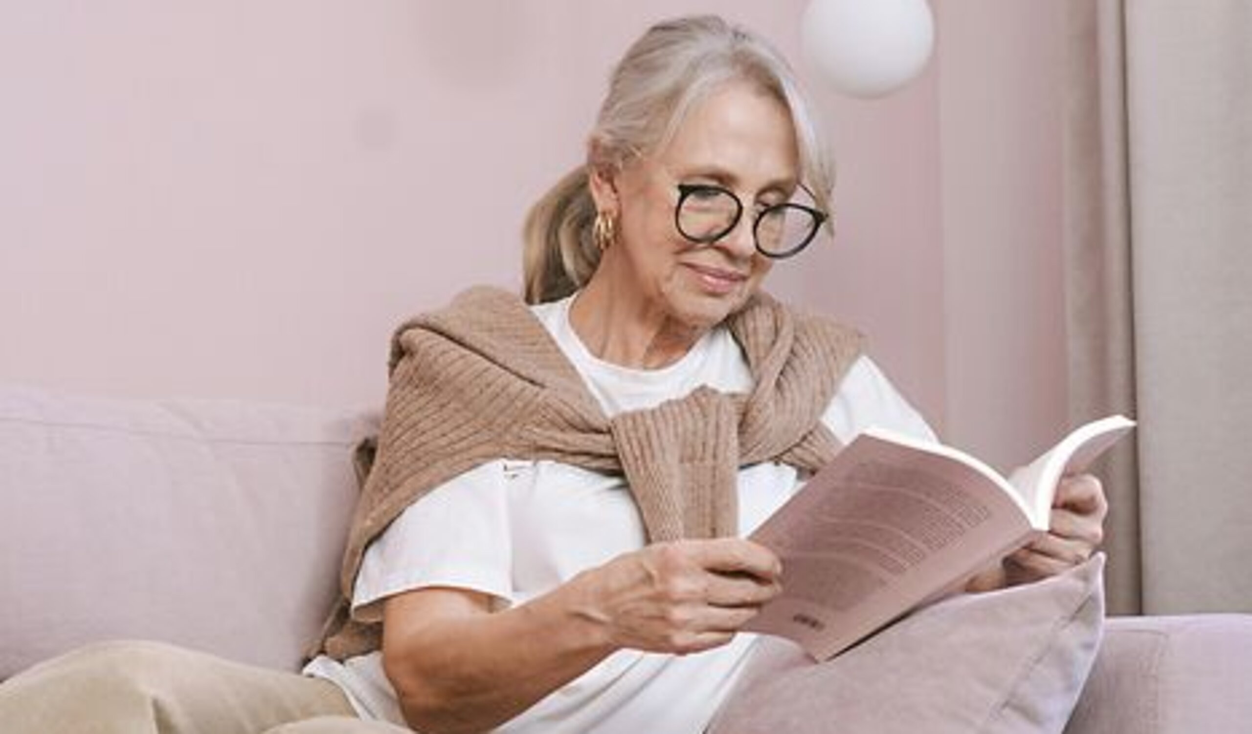 Frau ließt ein Buch Eine Frau ließt zuhause ein Buch auf dem Sofa.