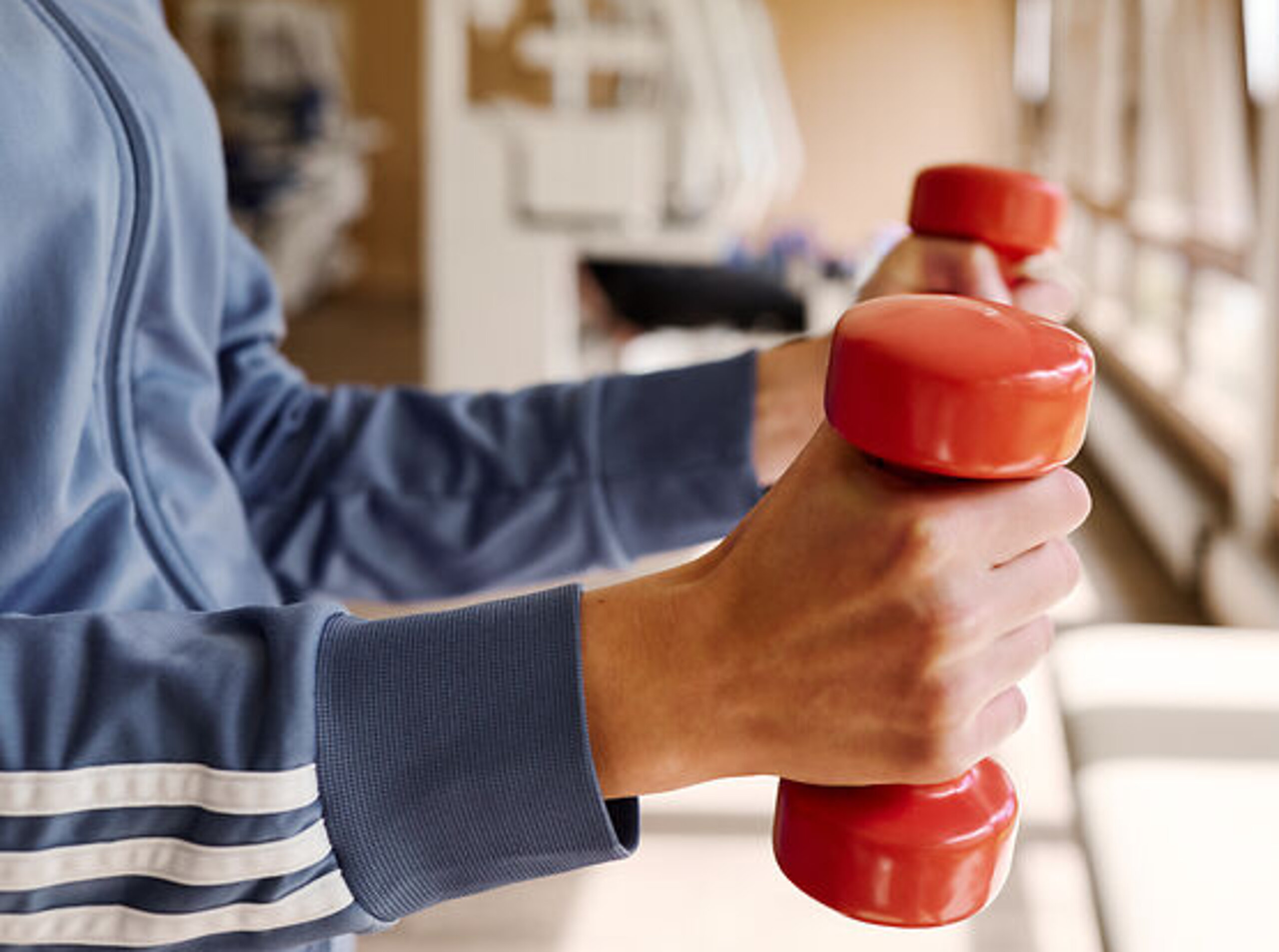 Hanteltraining Person mit Hanteln im MTT Raum.