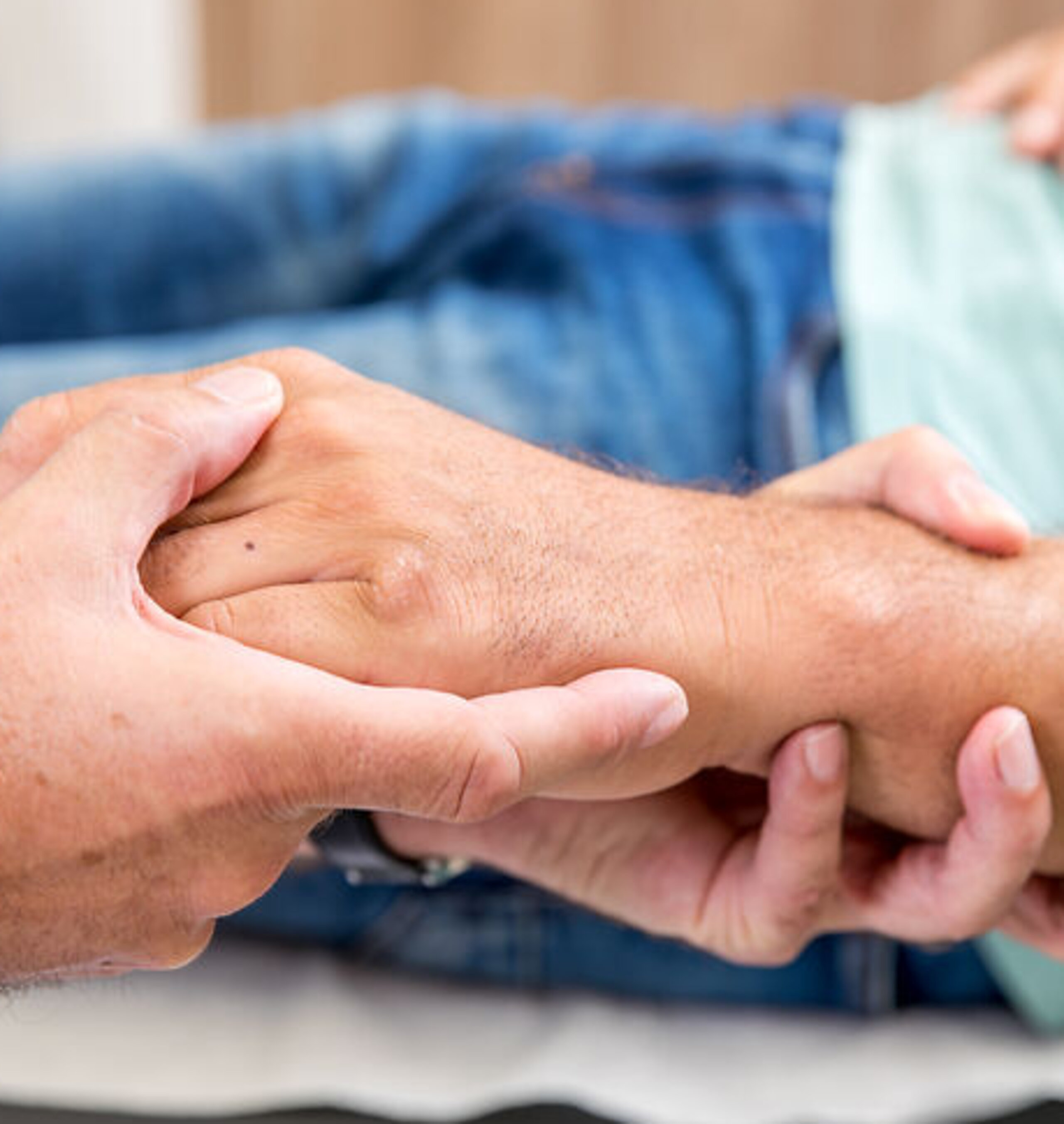 Hände Untersuchung Ein Arzt umfasst die Hand eines Patienten.