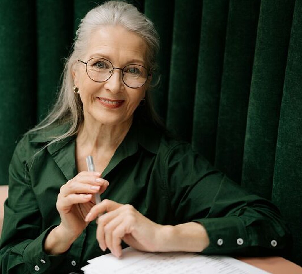 Frau mit Formular Eine Frau mittleren Alters füllt ein Formular aus.