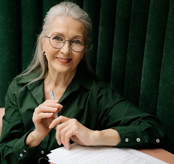 Eine Frau mittleren Alters füllt ein Formular aus.