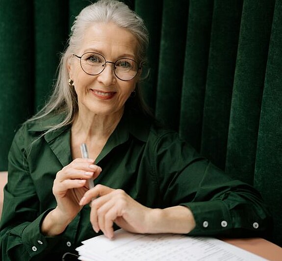 Frau mit Formular Eine Frau mittleren Alters füllt ein Formular aus.