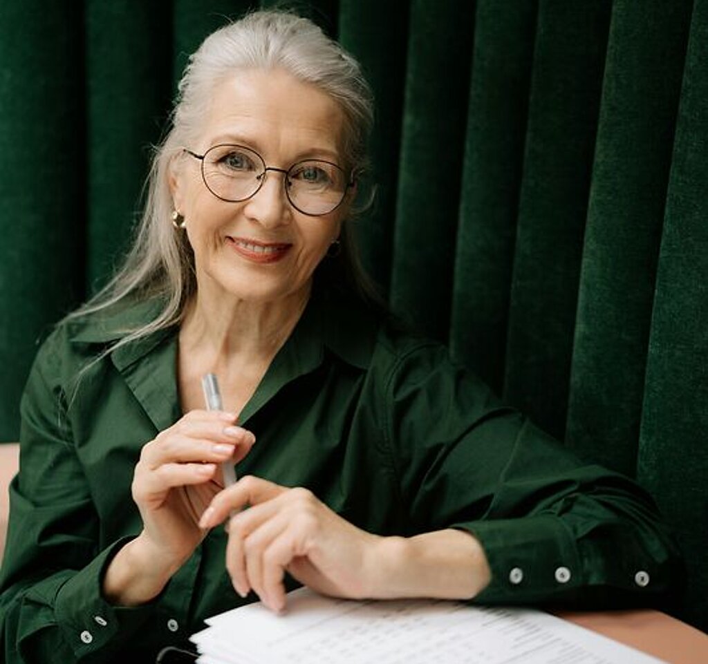 Frau mit Formular Eine Frau mittleren Alters füllt ein Formular aus.