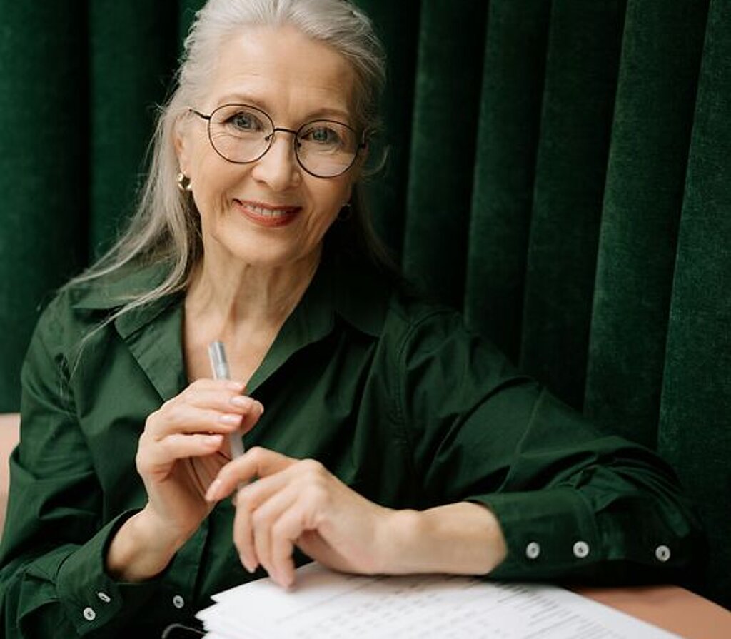 Frau mit Formular Eine Frau mittleren Alters füllt ein Formular aus.