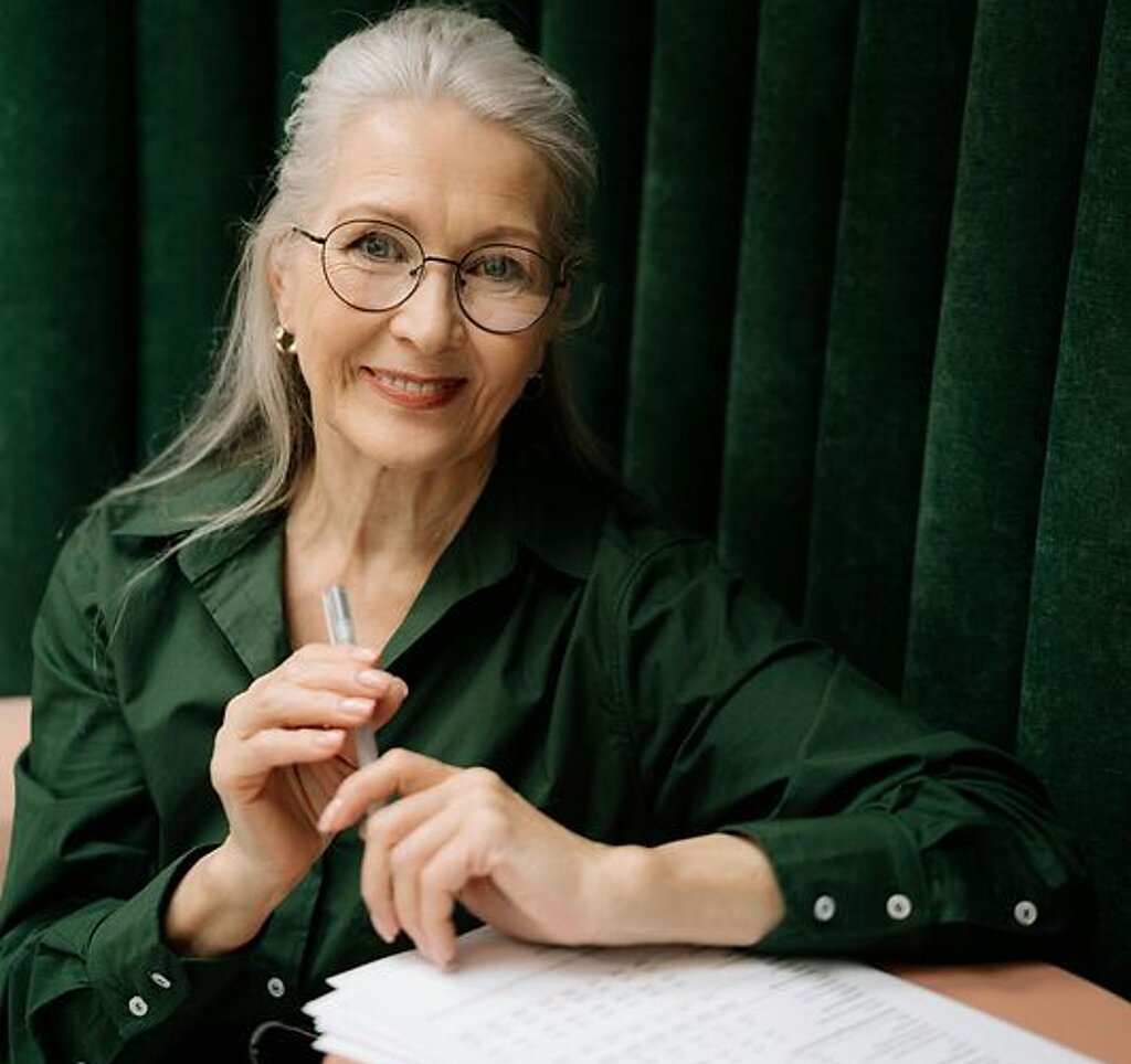 Frau mit Formular Eine Frau mittleren Alters füllt ein Formular aus.