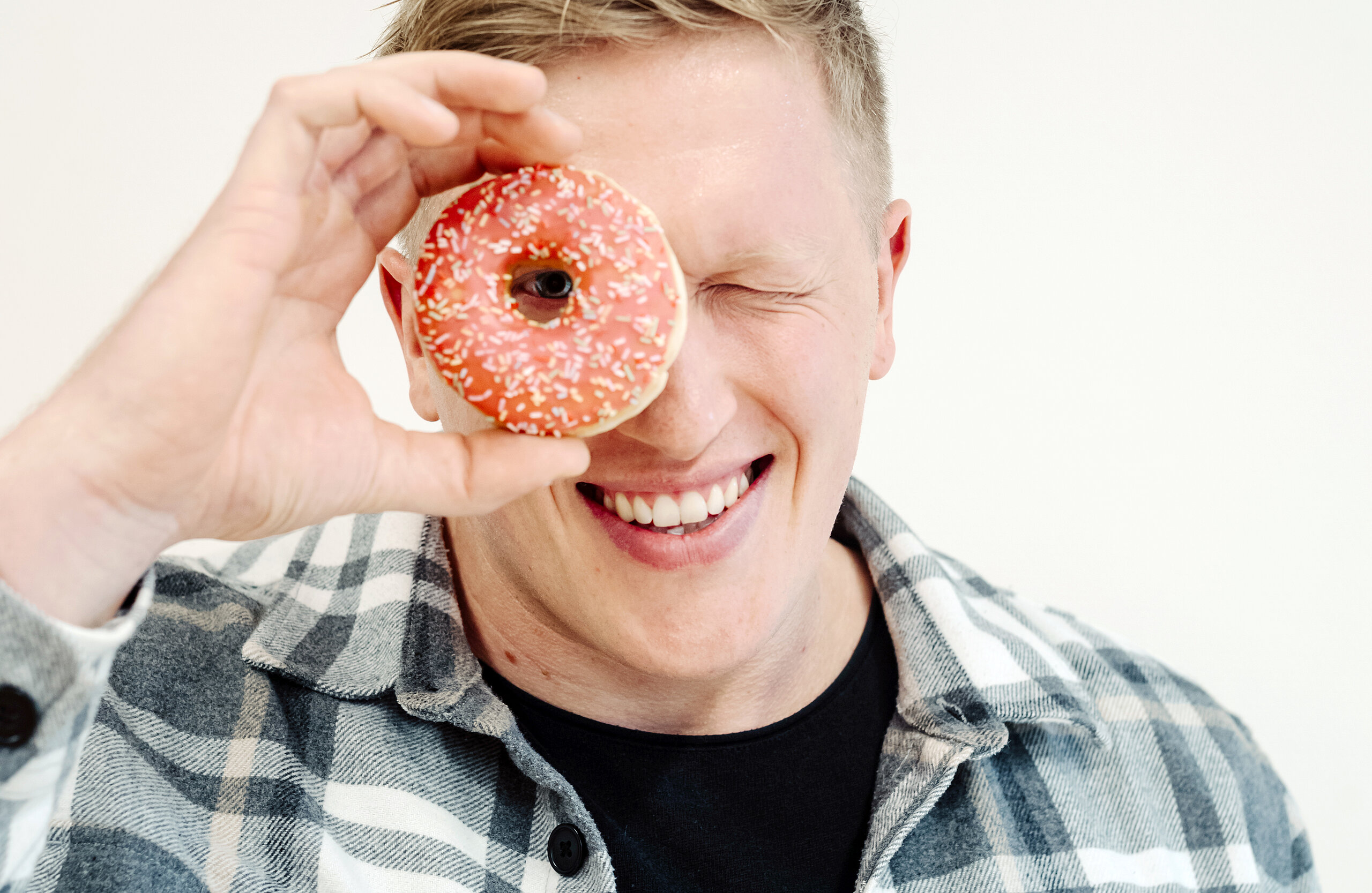 Jan Blaschko sieht mit einem Auge durch einen Donut.