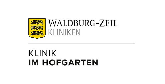 Farbiges Logo der Waldburg-Zeil Kliniken – Klinik im Hofgarten mit gelbem Wappen und schwarzem Schriftzug.