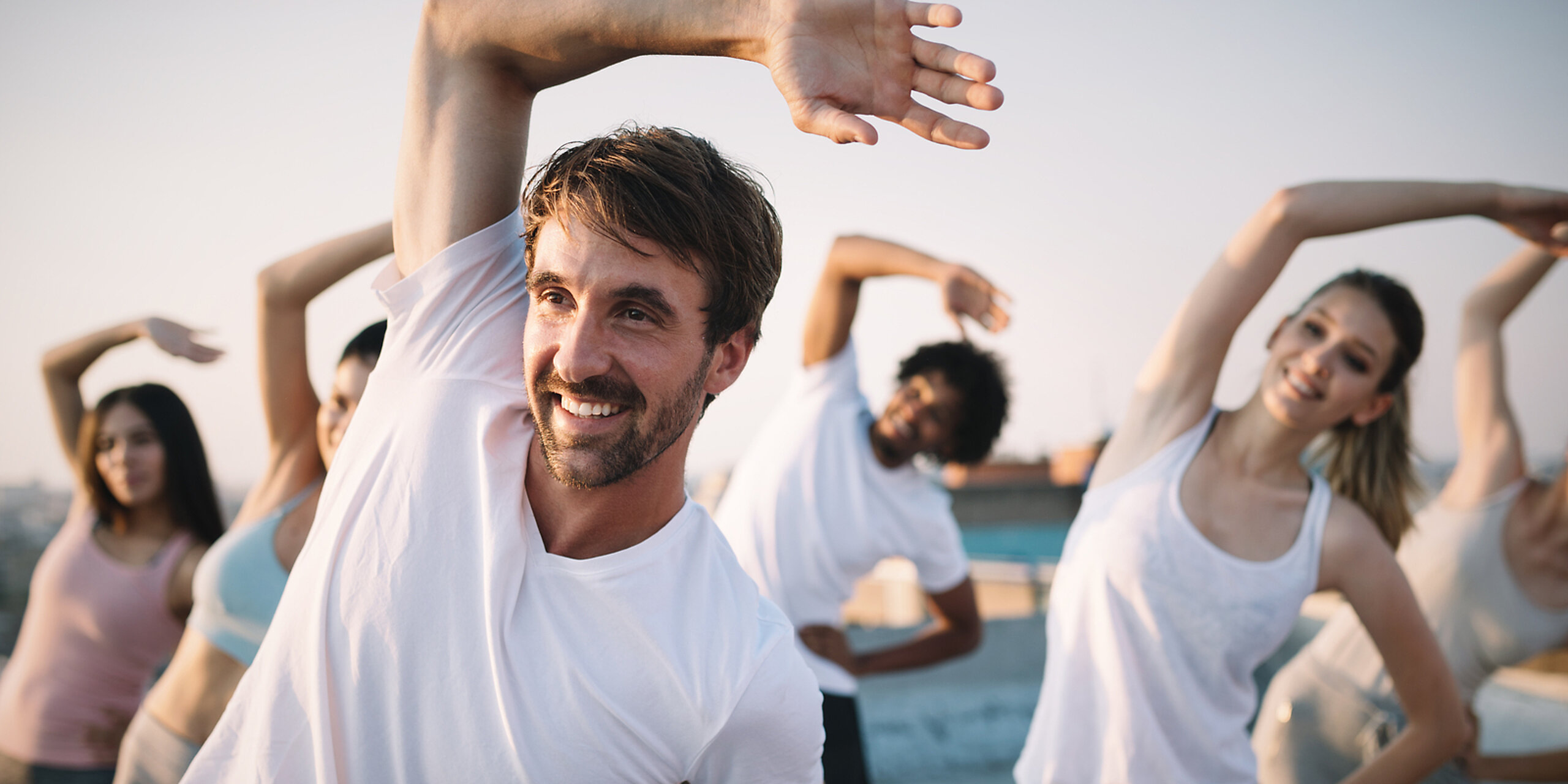 Eine Gruppe macht Dehnübungen im Freien.