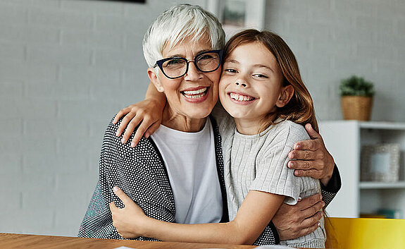 Oma und Kind Eine Oma und ihre Enkelin umarmen sich.