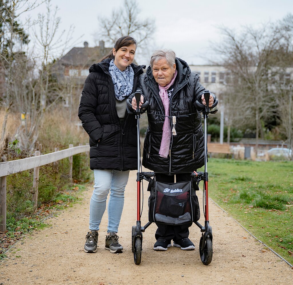 Ursel Kaiser bei einem Spaziergang mit dem Rollator in Begleitung.