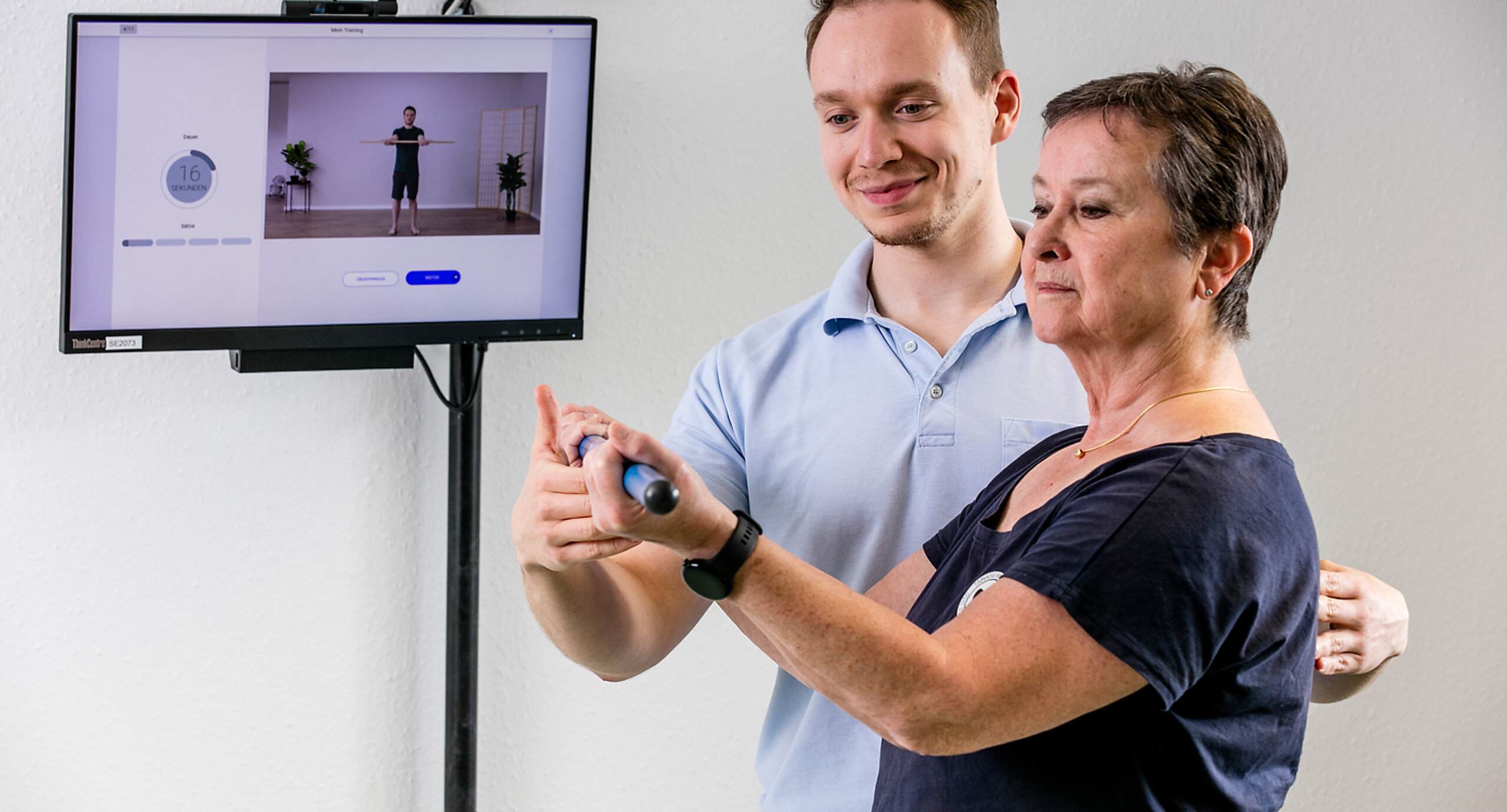 Ein Therapeut weist eine Patientin in die digitale Nachsorge ein