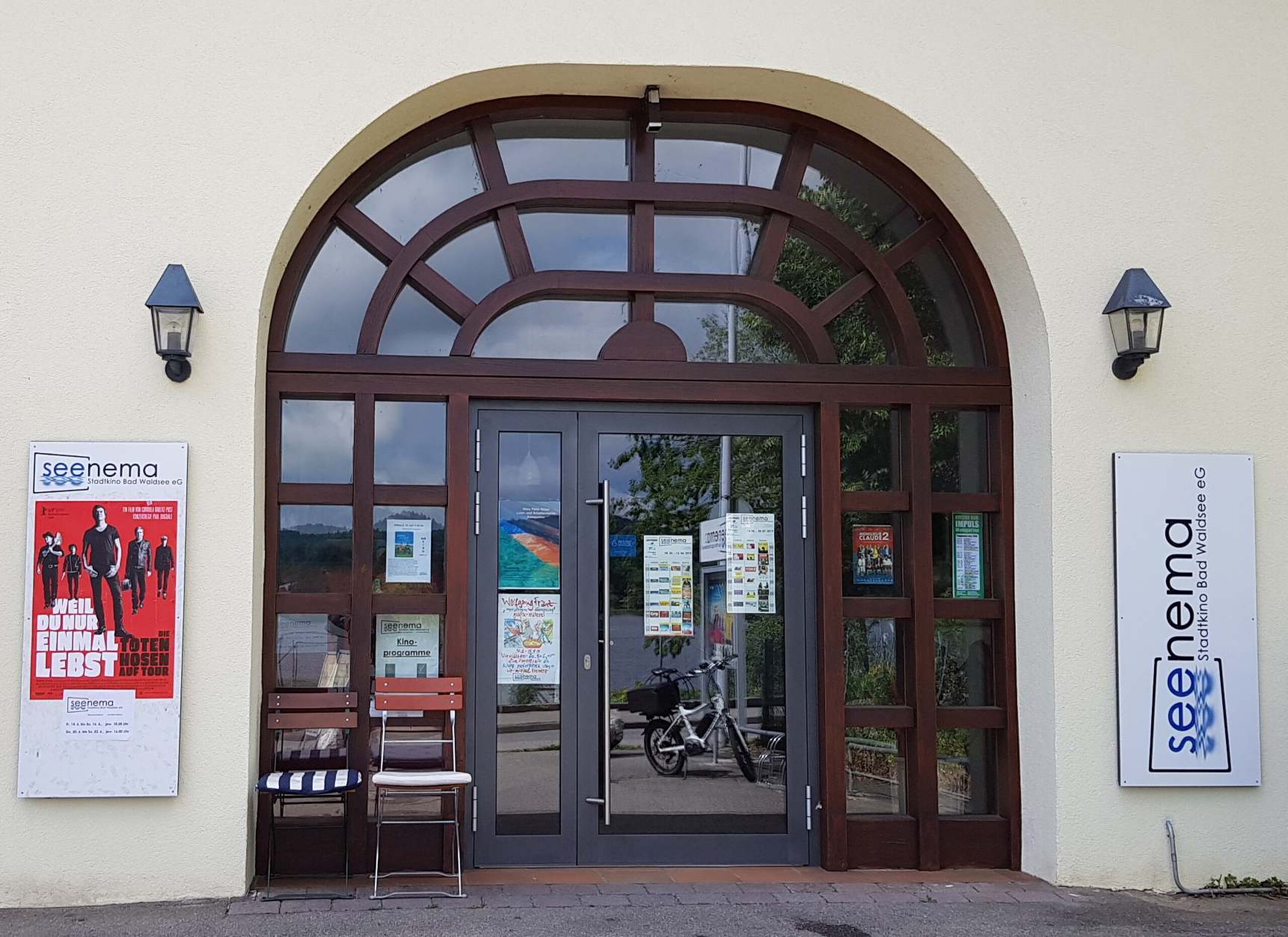 Eingang des Seenema-Kinos in Bad Waldsee mit Plakaten und Leuchtschild an der Fassade.