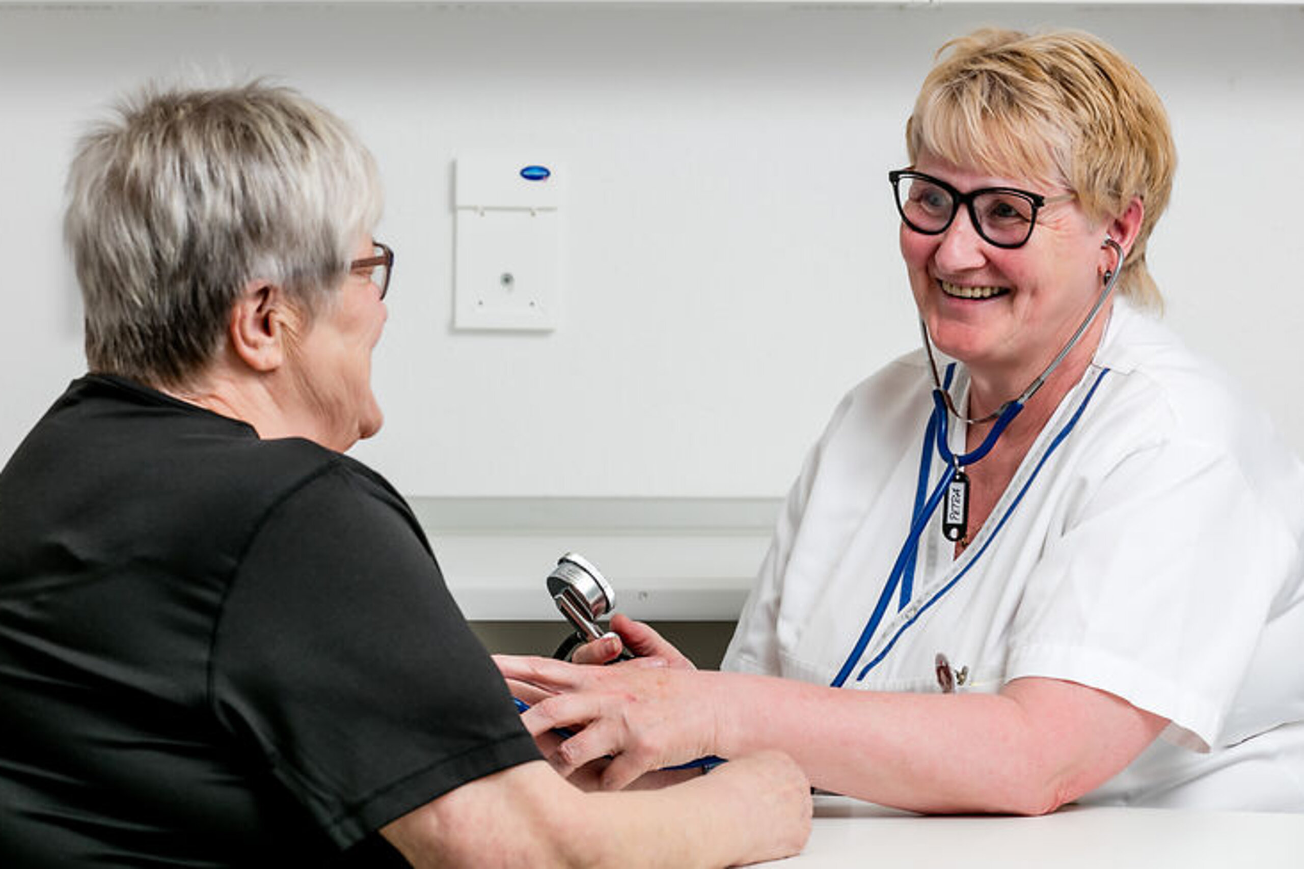 Eine Pflegekraft misst den Blutdruck einer Patientin.